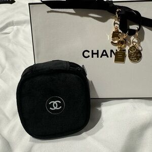 3 Chanel charms with a Chanel logo pouch..